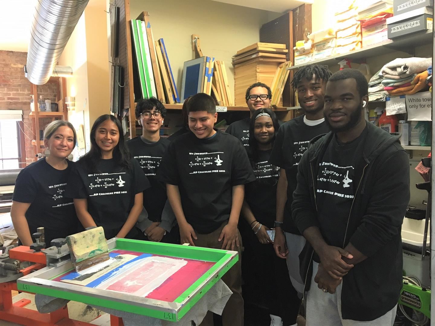  students pose with the T-shirt they designed. 
