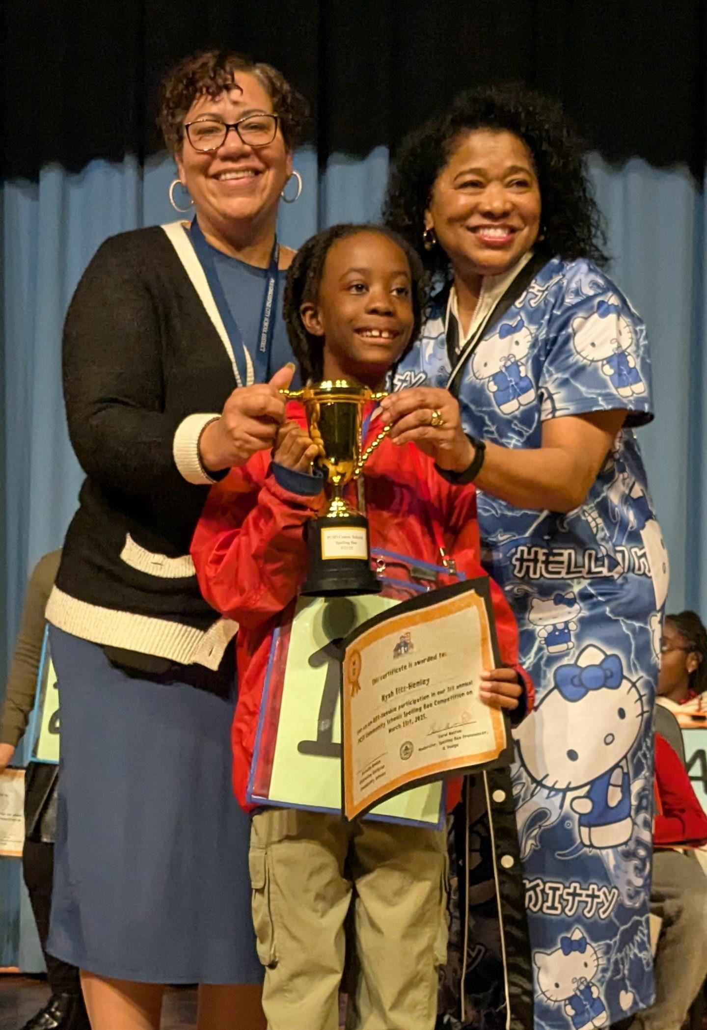 Community Schools Executive Director Natasha Brown, left, and moderator Carol Melton, pose with champion Nyah Fitz-Henley
