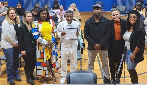 Joel Griffiths poses at the Poughkeepsie Board of Education meeting alongside his parents and administrators.