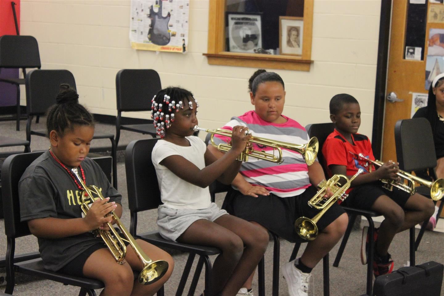 A student plays the trumpet in a music class