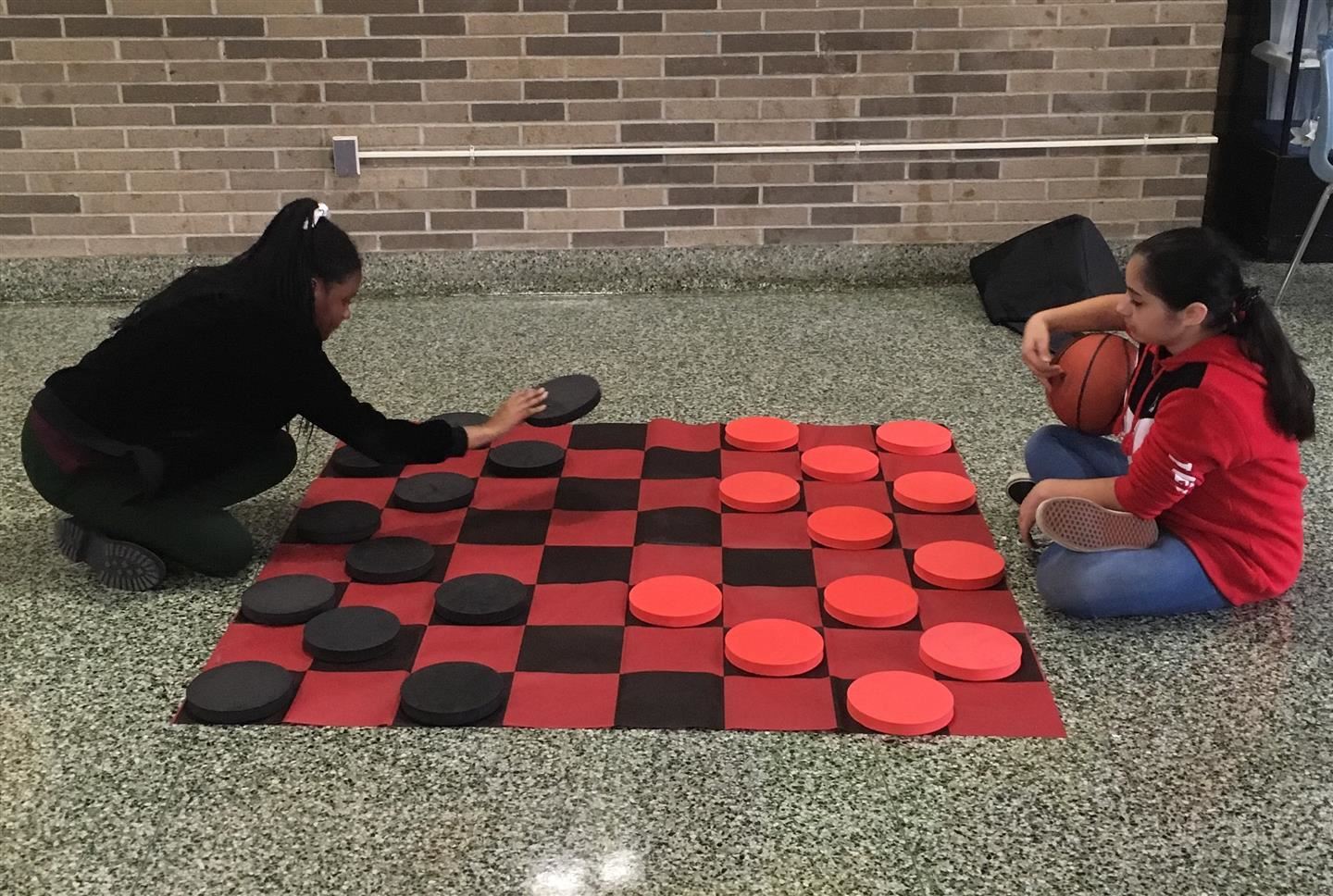  Two students play checkers on an enormous board