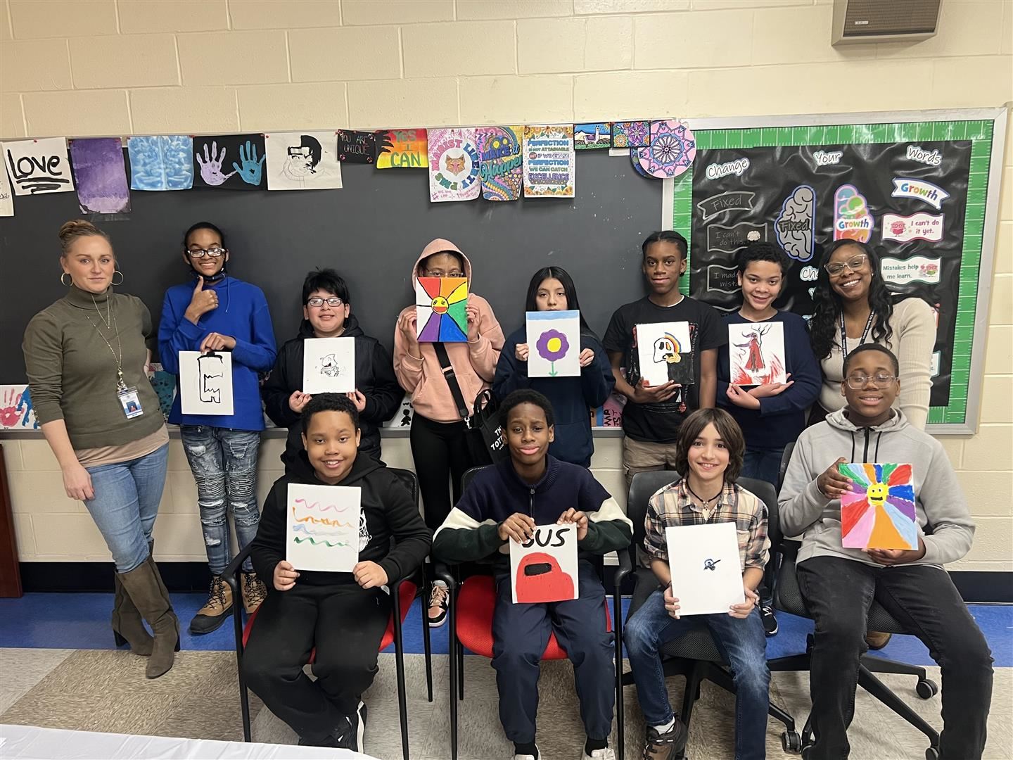 Two rows of students hold their art projects alongside two faculty members.