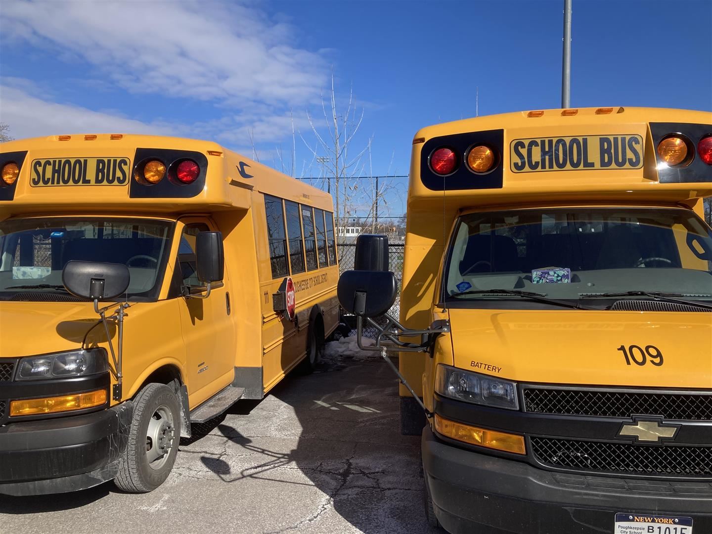  Two school buses sit in a lot