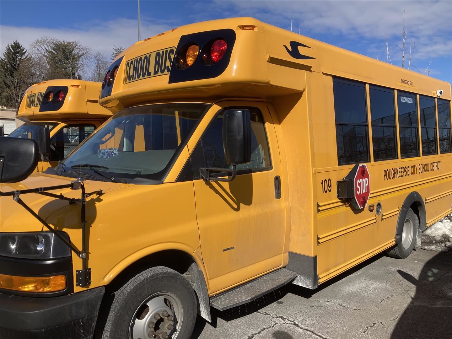  Two school buses are pictured in a lot