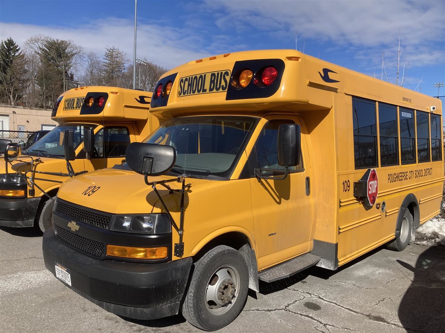  Two buses sit in a lot