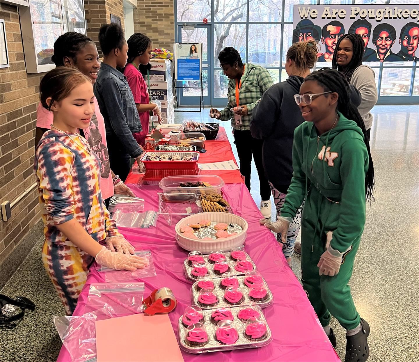  PMS' Sister 2 Sister members serve baked goods to a crowd of students and staff.
